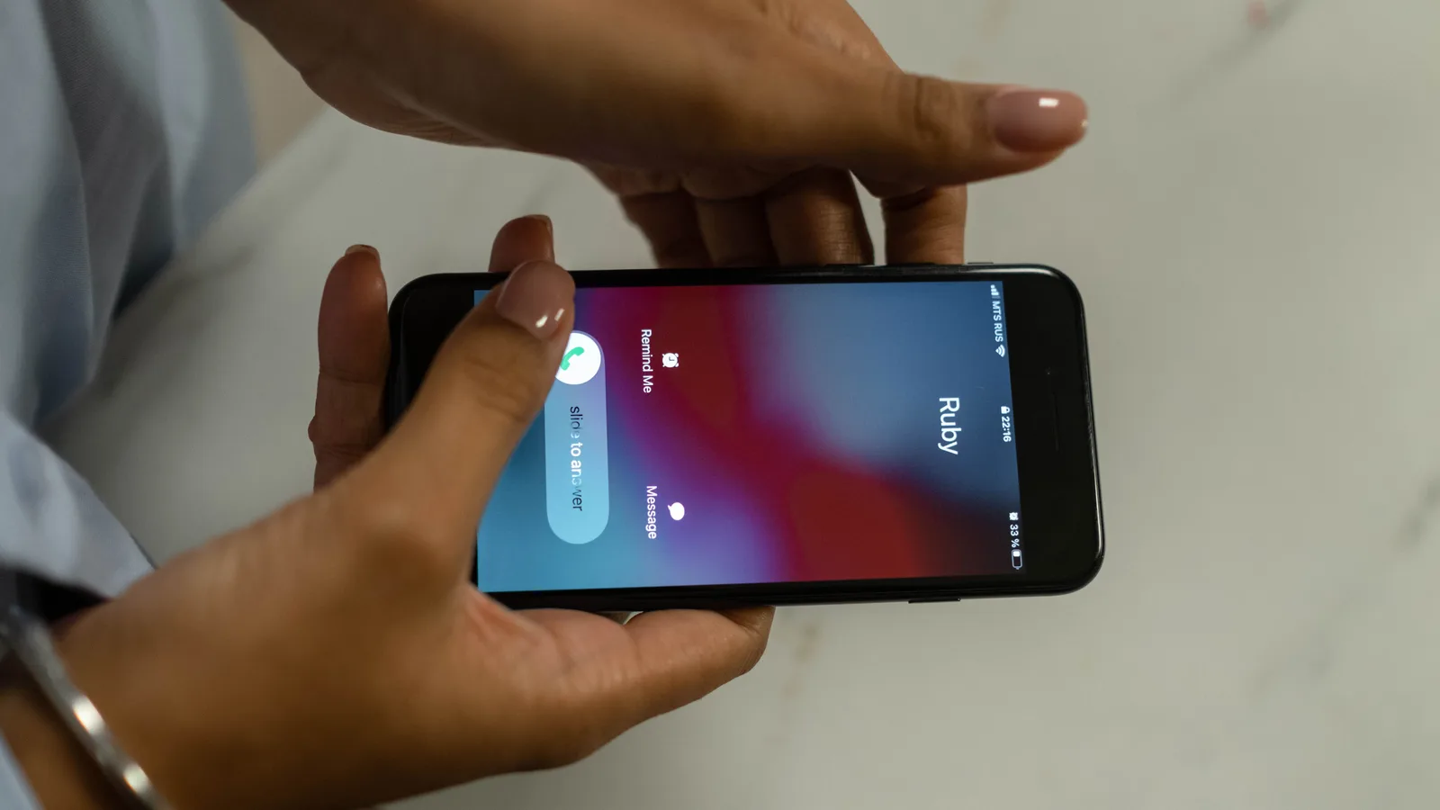 スマートフォンの着信画面を持つ手